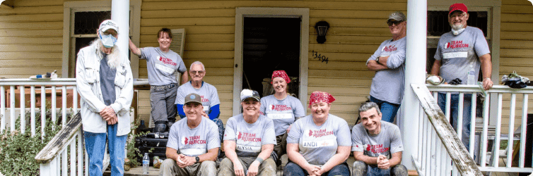 Team Rubicon staff together looking happy and proud on a porch